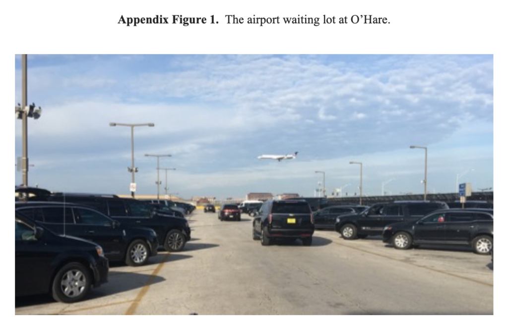 A plane lands at O'Hare airport, seen from the taxi parking lot.